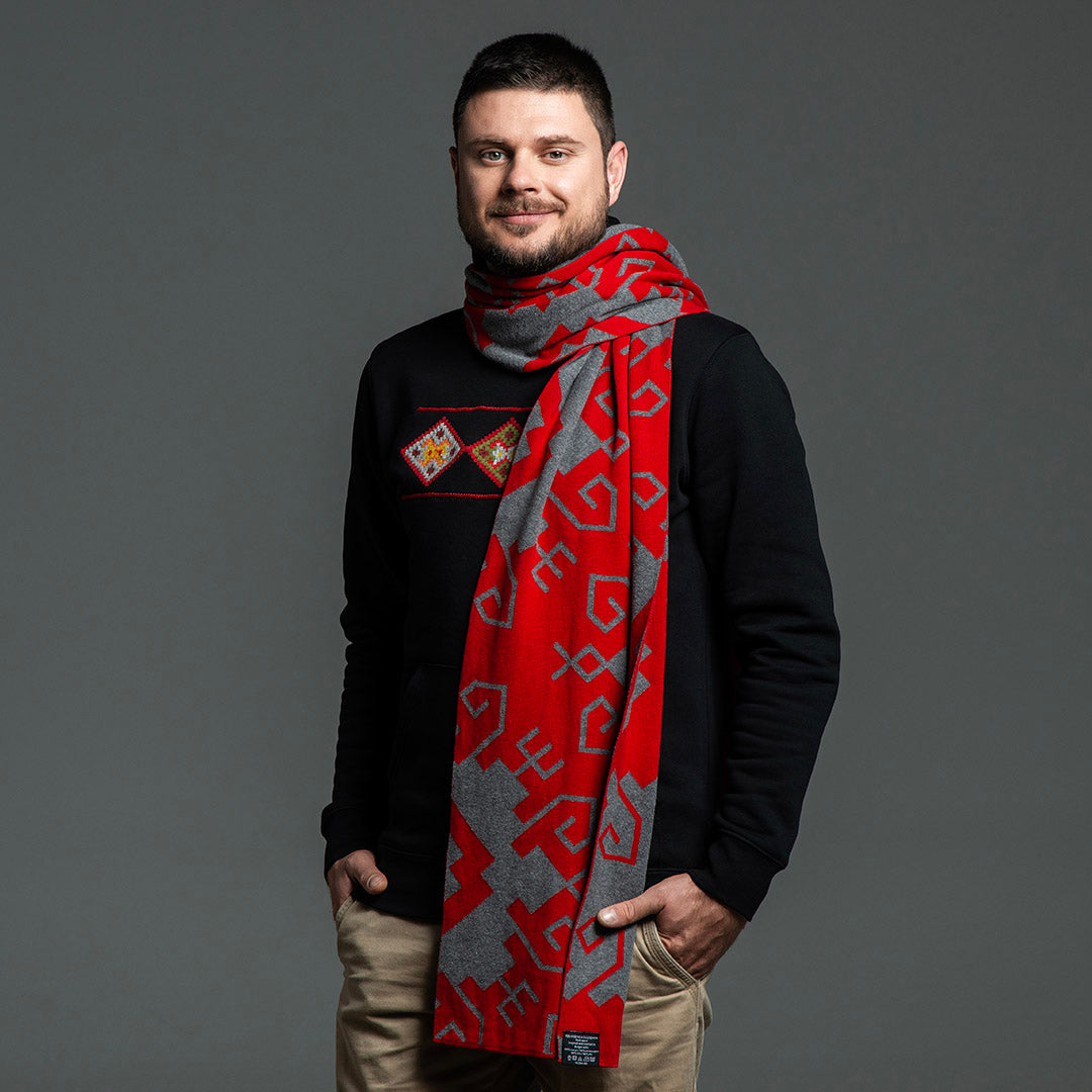 Мъж с червено-сив жакардов шал "Елбетица" с осемлъчни звезди, увит около врата